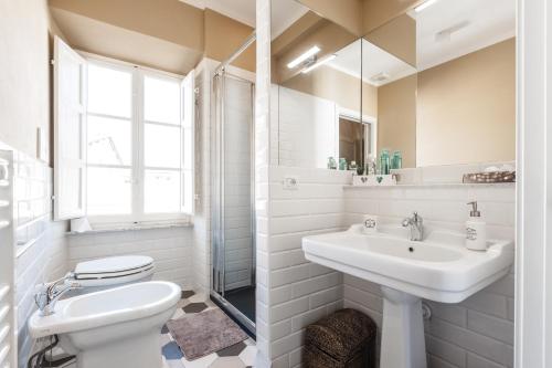 een witte badkamer met een wastafel en een toilet bij Affordable suite with a view in the Heart of Lucca in Lucca