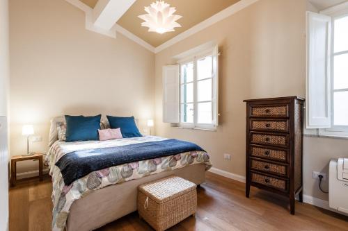 een slaapkamer met een groot bed met blauwe kussens bij Affordable suite with a view in the Heart of Lucca in Lucca
