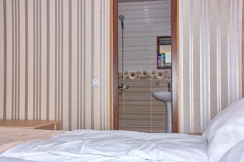 a bedroom with a bed and a bathroom with a sink at Light House Old City in Akhaltsikhe