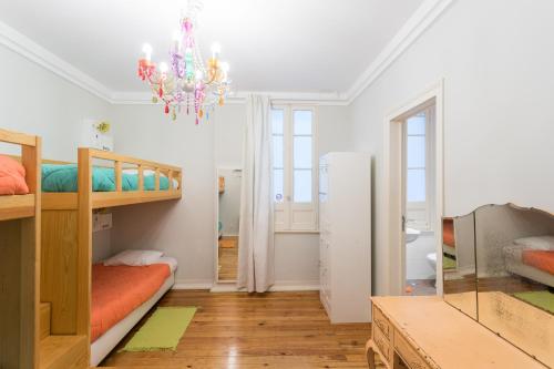 a room with two bunk beds and a chandelier at Lisboa Central Hostel in Lisbon