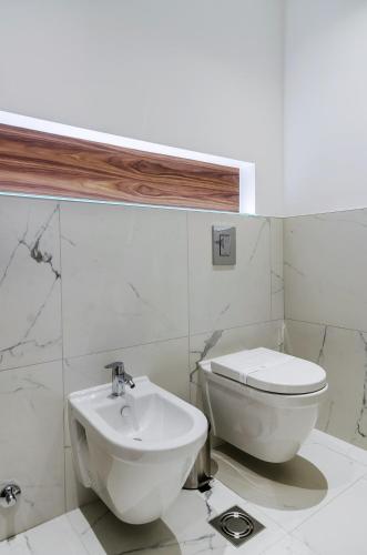 a white bathroom with a toilet and a sink at Room 25 Belgrade in Belgrade