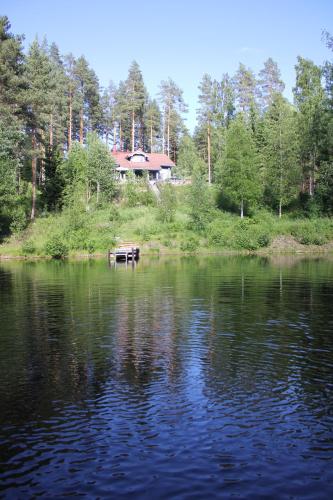 a house sitting on the shore of a lake at Tervalepikon Torpat in Sysmä