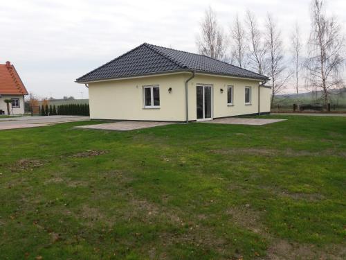 une petite maison blanche avec une grande cour dans l'établissement Störtebeker 13, à Gnies