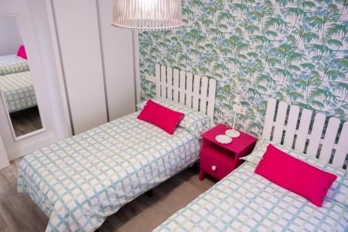 a room with two twin beds and a mirror at Apartamento Valtour Valladolid in Valladolid