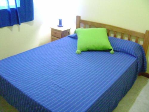 a blue bed with a green pillow on it at HUGO 3 in Colón