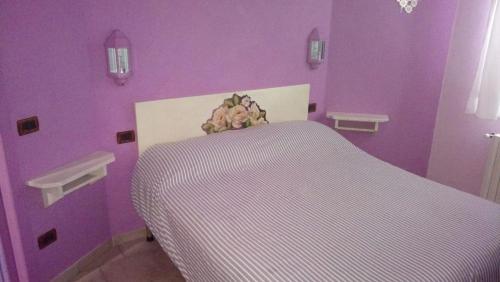 Dormitorio púrpura con cama con pared púrpura en B&b La Violetta, en SantʼAnna Pelago