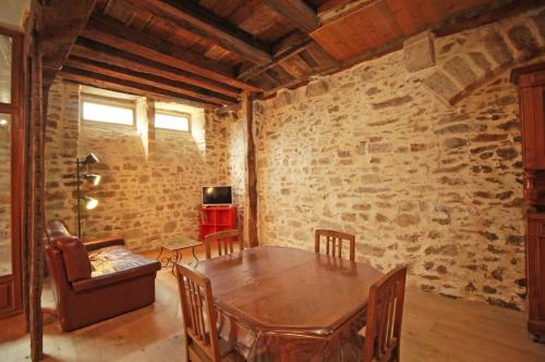 sala de estar con mesa de madera y silla en La Rapiette de Noblat, en Saint-Léonard-de-Noblat