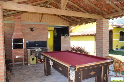 a pool table in a patio with a fireplace at Pousada Trilha do Ouro Alagoa MG in Alagoa