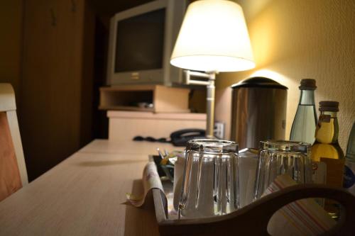 einen Tisch mit einer Lampe und Gläsern darauf in der Unterkunft Landgasthof Hock in Großostheim