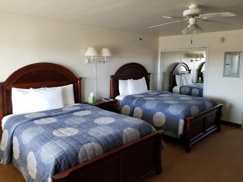 a hotel room with two beds and a mirror at Shore Stay Suites in Cape Charles