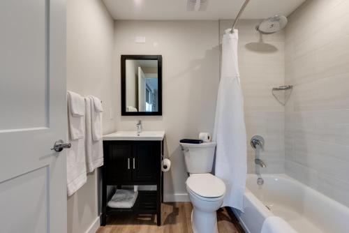 a bathroom with a toilet and a sink and a tub at Escape Coastal Resort on Casey Key in Nokomis