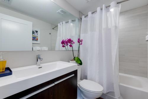a bathroom with a sink and a toilet and a shower at Escape Coastal Resort on Casey Key in Nokomis