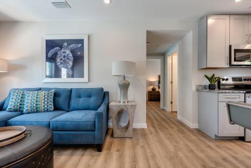 a living room with a blue couch and a kitchen at Escape Coastal Resort on Casey Key in Nokomis