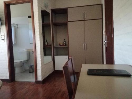 a room with a bathroom with a toilet and a table at Hotel Juana de Ibarbourou in Melo