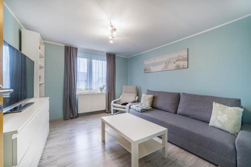 a living room with a couch and a table at Apartamenty Mewa in Rewa