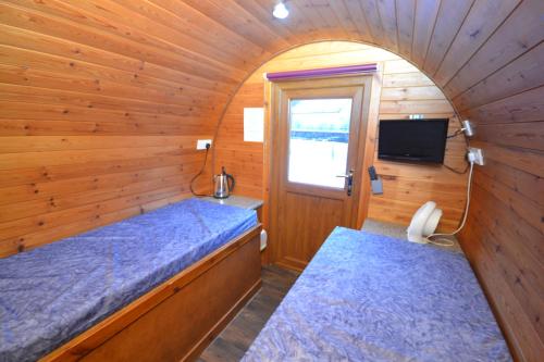 a bedroom with a bed and a window at Glamping Pods in Kinlochleven