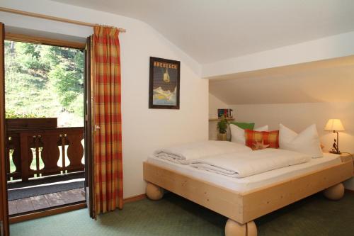 a bedroom with a bed and a balcony at Ferienwohnungen Wurzer Toni in Grainau