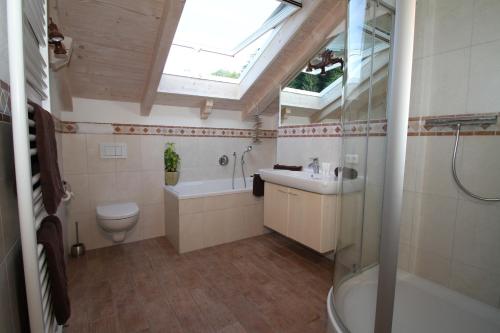 a bathroom with a sink toilet and a skylight at Ferienwohnungen Wurzer Toni in Grainau