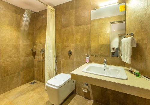 a bathroom with a sink and a toilet and a shower at Aura One Hotel in Cochin