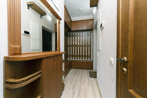 a hallway with a door leading to a kitchen with wood at Apart Assistant on Smart Plaza in Kyiv