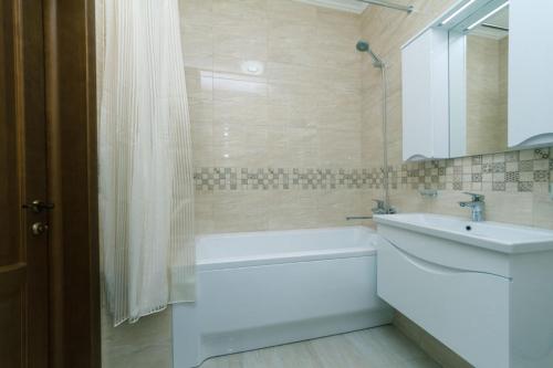 a bathroom with a bath tub and a sink and a bath tubermott at Apart Assistant on Smart Plaza in Kyiv