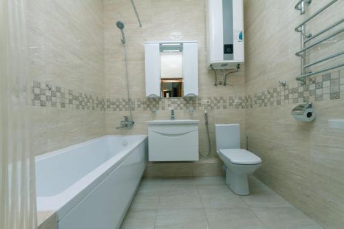 a bathroom with a tub and a toilet and a sink at Apart Assistant on Smart Plaza in Kyiv