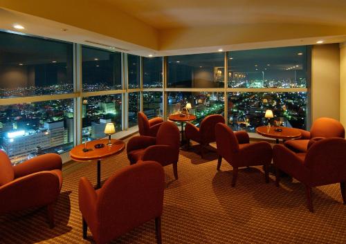 a restaurant with tables and chairs and a view of a city at HOTEL GRAND HILLS SHIZUOKA in Shizuoka