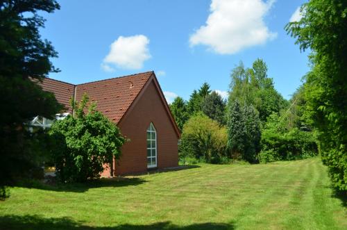 a small red church with a large grass yard at Gästehaus Vigliarolo gewerblich Jedes Zimmer eigenes Bad Gemeinschaftsküche in Elmshorn