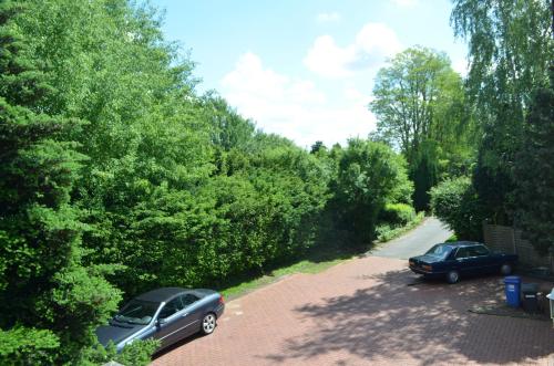 two cars parked in a parking lot next to a road at Gästehaus Vigliarolo gewerblich Jedes Zimmer eigenes Bad Gemeinschaftsküche in Elmshorn