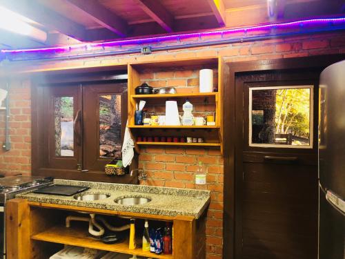 a kitchen with a sink and a brick wall at Casa de Ines em Santana in São Marcos