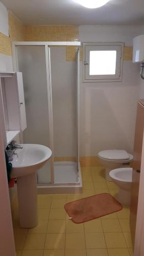 een badkamer met een douche, een toilet en een wastafel bij Casa vacanze Arimondi in Porto Cesareo