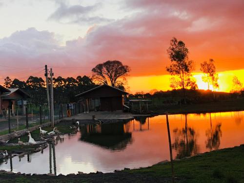 um pôr-do-sol sobre um corpo de água com pássaros nele em Casa de Ines em Santana em São Marcos