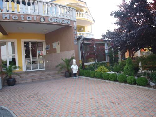 a man standing in front of a building at Hotel Orion in Ivanec