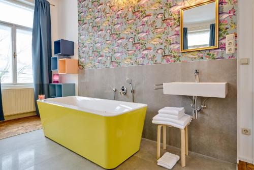 a bathroom with a yellow tub and a sink at Leuhusen Collection Vienna, Wien in Vienna
