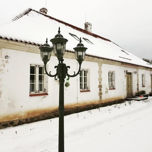 a street light in front of a house in the snow at Torma Puhkemaja ja Glämping in Torma