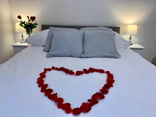 a heart made out of red roses on a bed at Willa Beskidzka in Myślenice