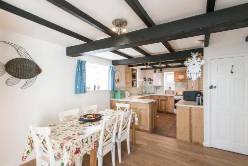 cocina y comedor con mesa y sillas en Leo's Cottage en St Ives