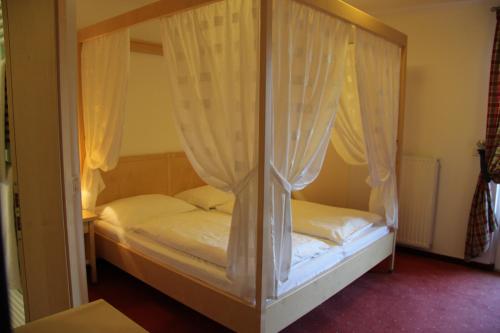 a bedroom with two beds with white curtains at Hotel Hanny in Bolzano