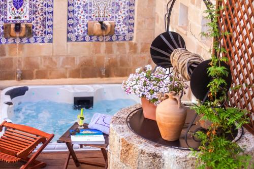 un patio con una bañera con flores y una mesa en In Camera Art Boutique Hotel en Rodas