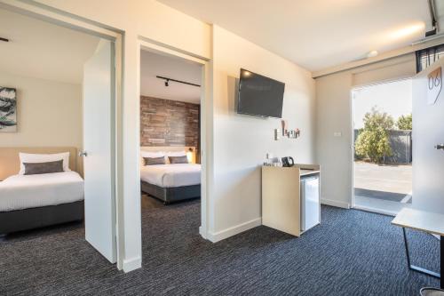 um quarto de hotel com duas camas e uma televisão em Nightcap at Westside Hotel em Laverton