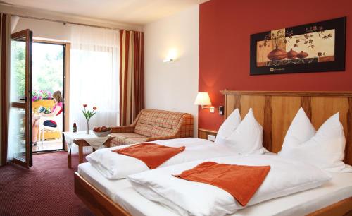una camera d'albergo con letto e sedia di Gasthof zum Bäckerwirt a Chamerau