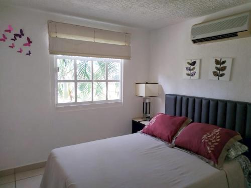 a bedroom with a bed and a window at Departamento Las Gaviotas in Acapulco