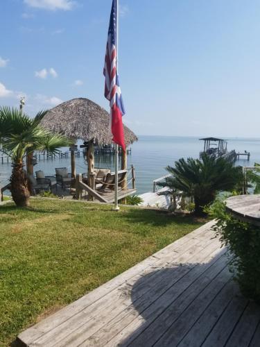 uma bandeira americana num passeio ao lado de uma praia em Come Friday Cottages em Bacliff