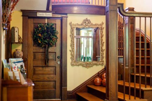 a hallway with a wooden door and a mirror at Hart House Bed & Breakfast in Hart