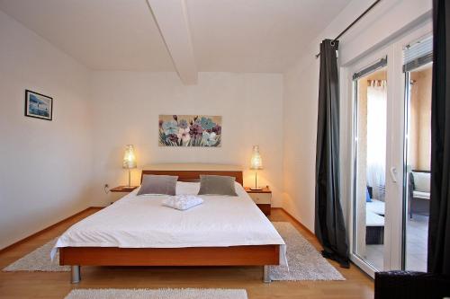 una camera da letto con un letto e una grande finestra di Apartments Mara a Supetar (San Pietro di Brazza)