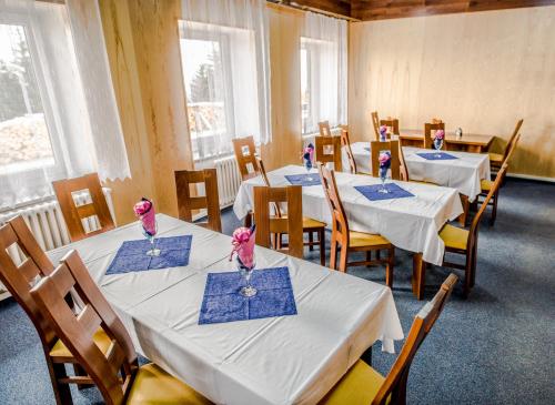 un comedor con mesas y sillas con ratones rosas. en Horský hotel Kozubová en Dolní Lomná