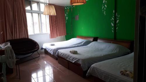 a bedroom with two beds and a green wall at 太魯閣蘇西小空間 SusiSpace in Xincheng
