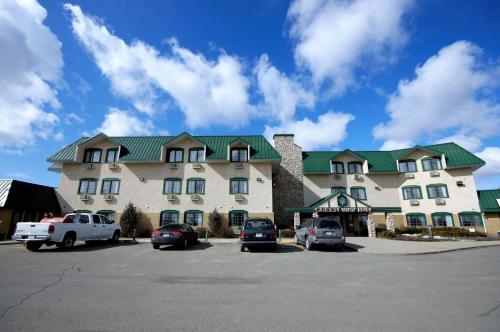 a large building with cars parked in a parking lot at Travelodge by Wyndham Lacombe in Lacombe