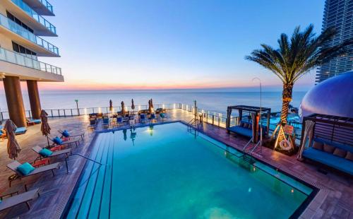 a swimming pool with a view of the ocean at Luxury Beach Resort in Hollywood