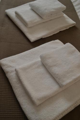 three white towels sitting on top of a table at Tres Puentes Anguiano Apartamentos y Hostal in Anguiano